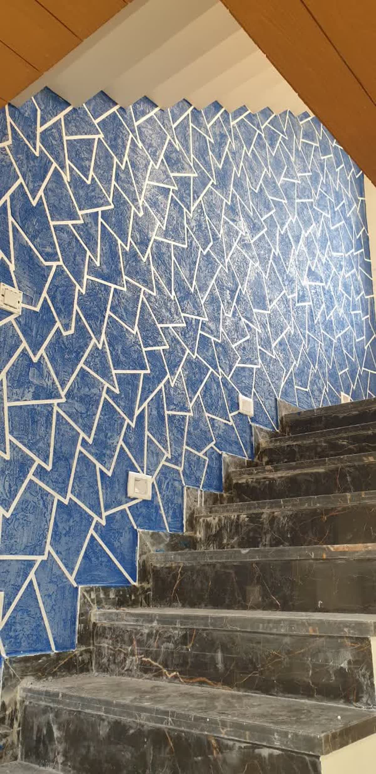 Fragmented blue mosaic texture wall beside a marble stairwell