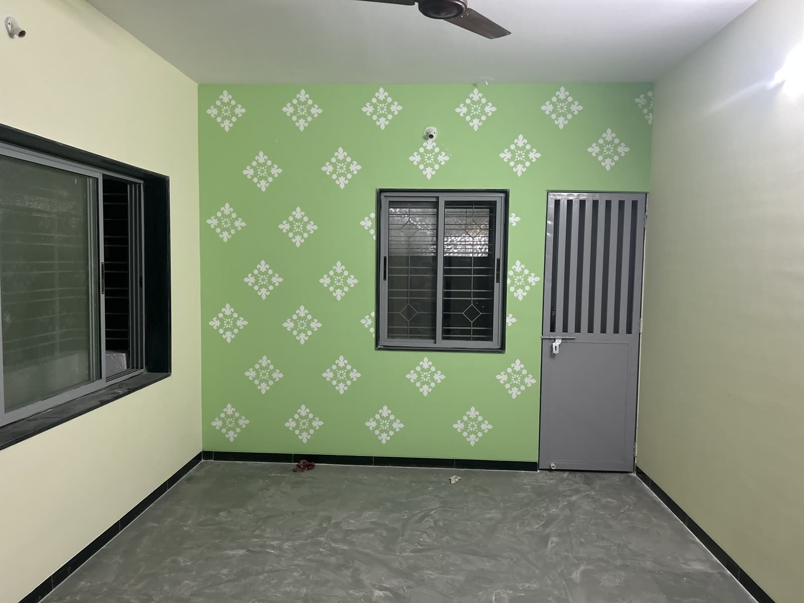 Hand-stenciled damask motif on a sage green accent wall