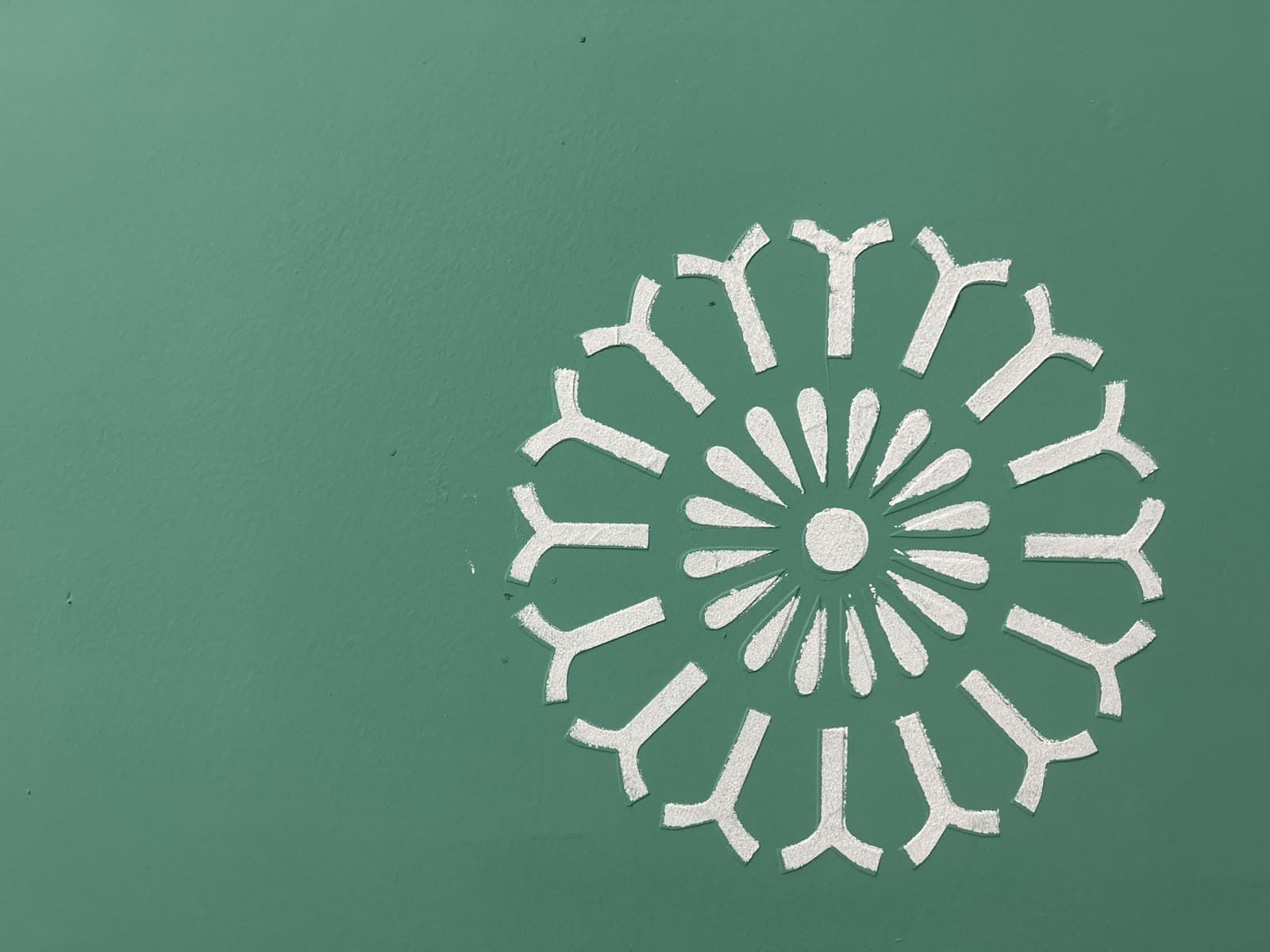 Close-up of a hand-stenciled mandala flower motif
