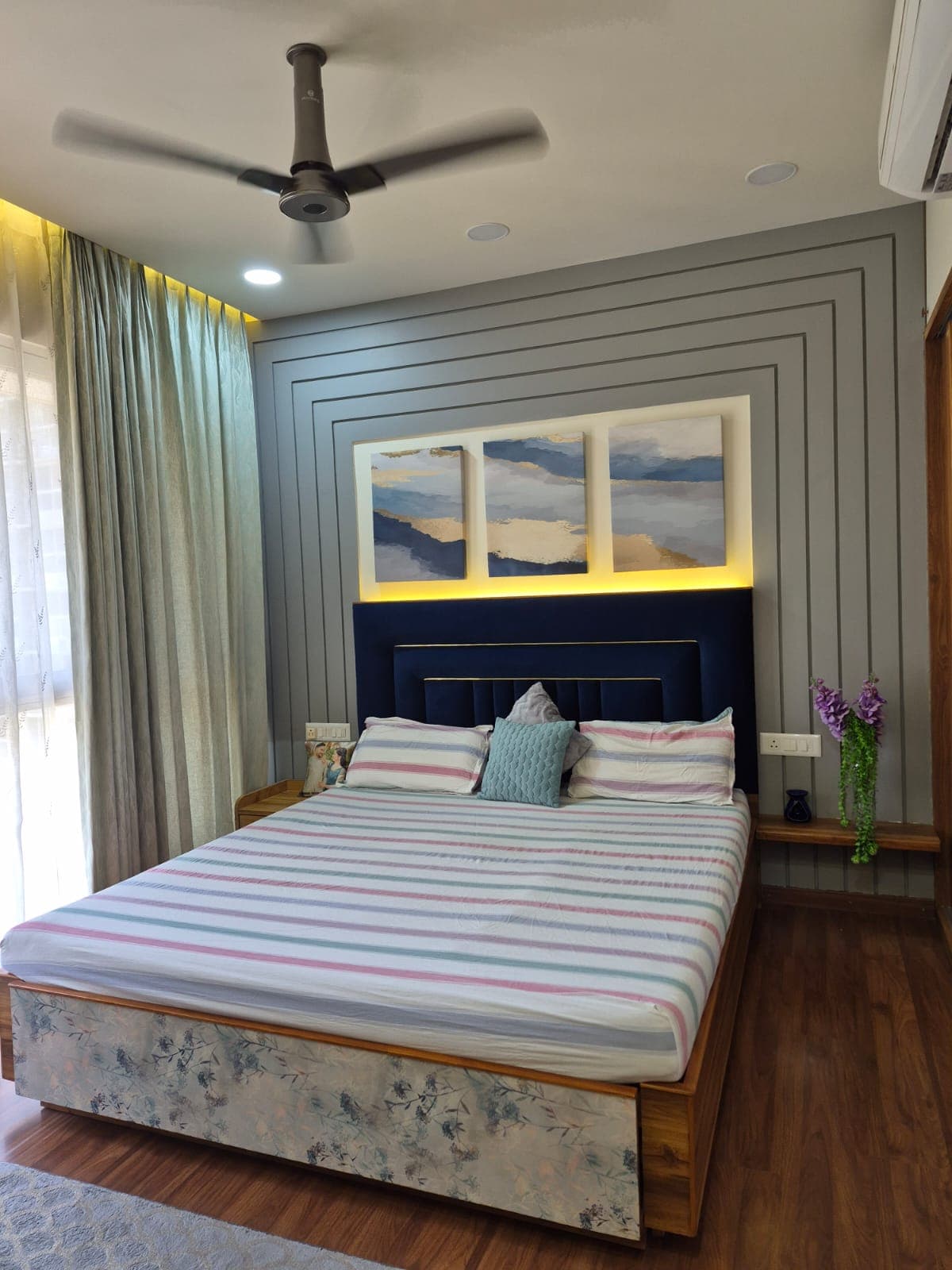 Premium bedroom interior with navy upholstered headboard and paneled feature wall