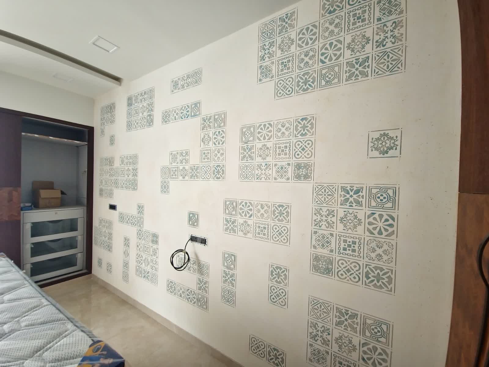 Hand-stenciled Moroccan tile motif on a bedroom feature wall